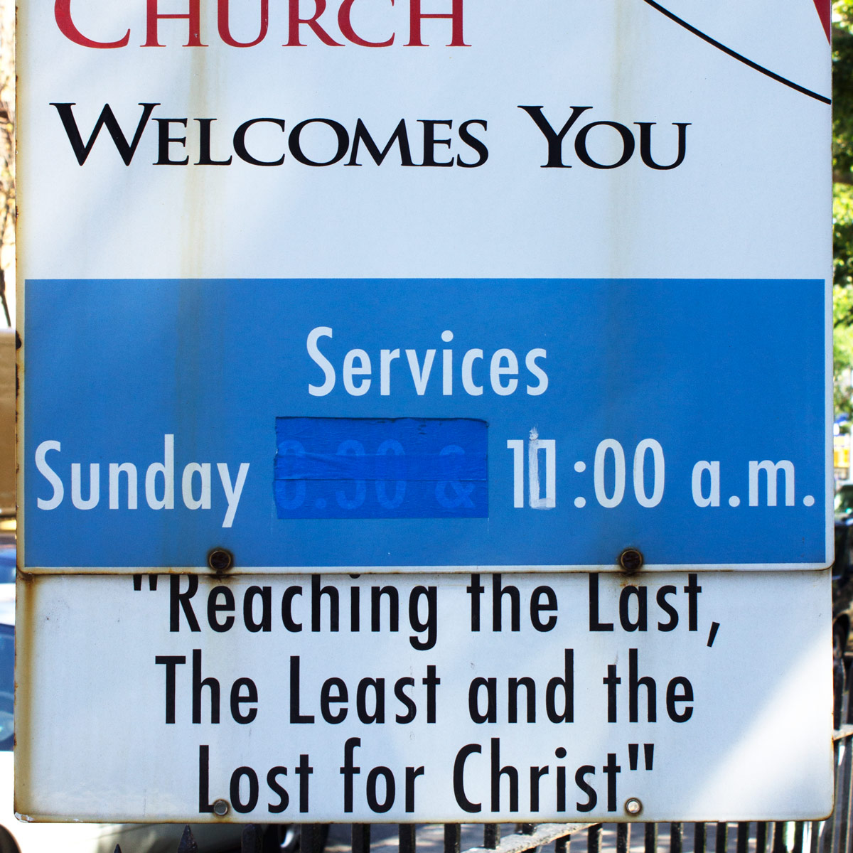 Church service sign where ‘8:30’ has been taped over and ‘10:00’ has been painted over so that it now reads ‘11:00’
