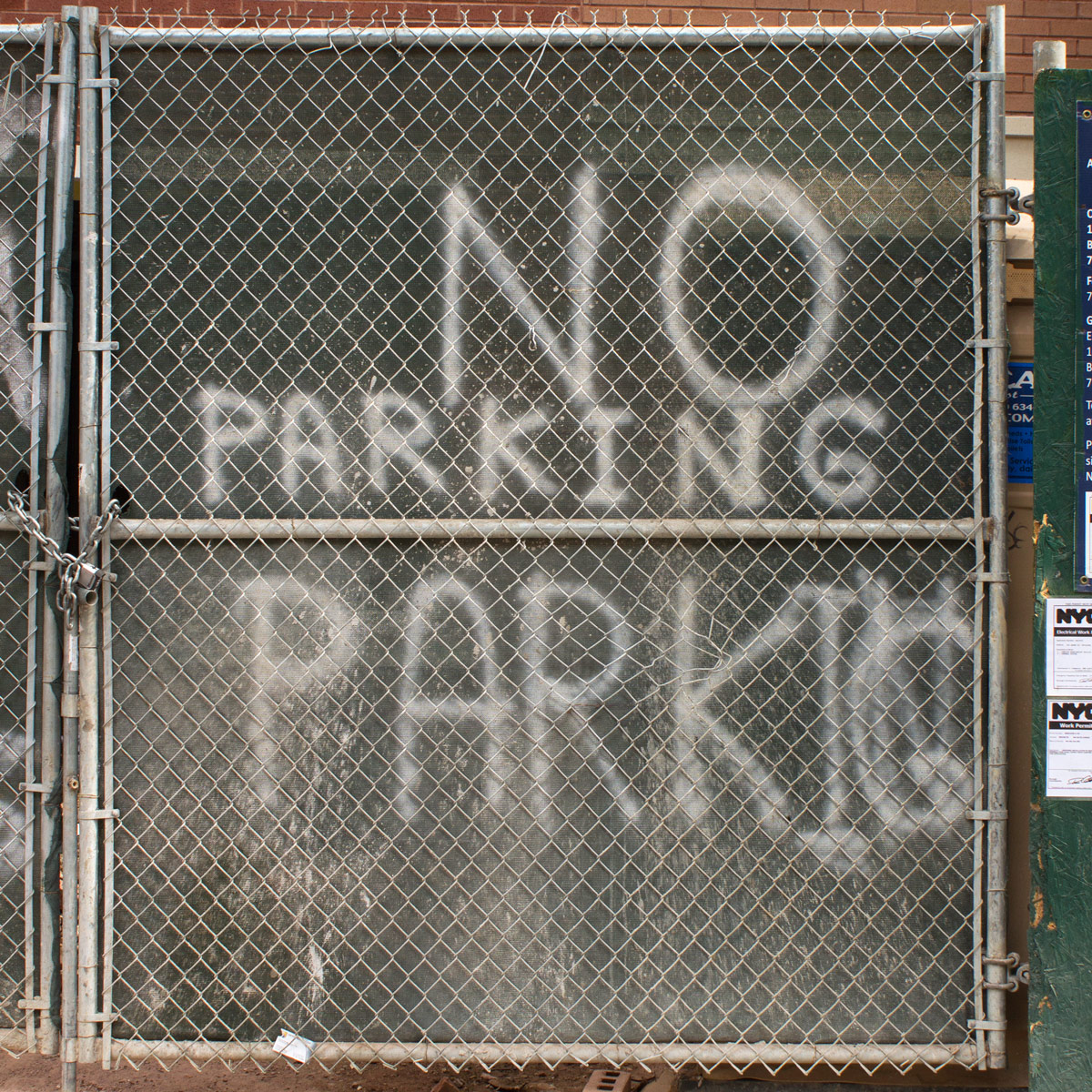 Spray-painted ‘no parking’ sign where signmaker ran out of room and had to rewrite ‘parking’ a second time, above the first attempt and noticeably smaller
